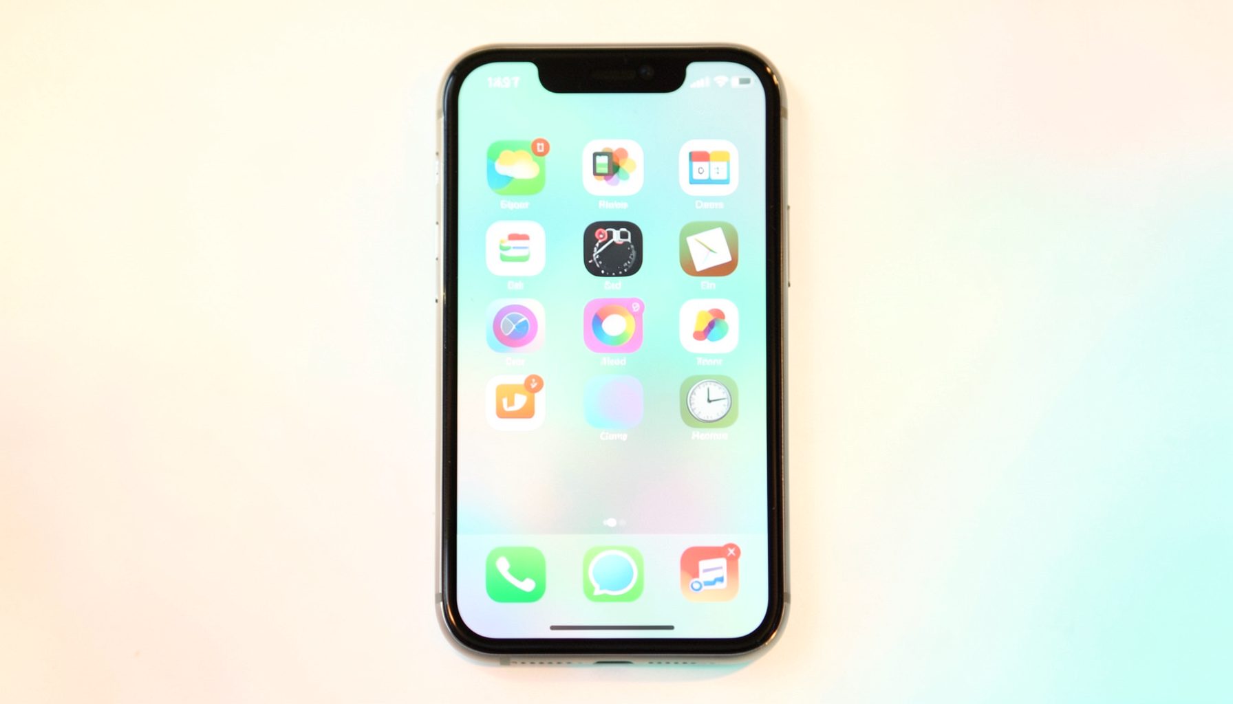 A smartphone screen displaying colorful app icons against a soft gradient background in warm pastel tones