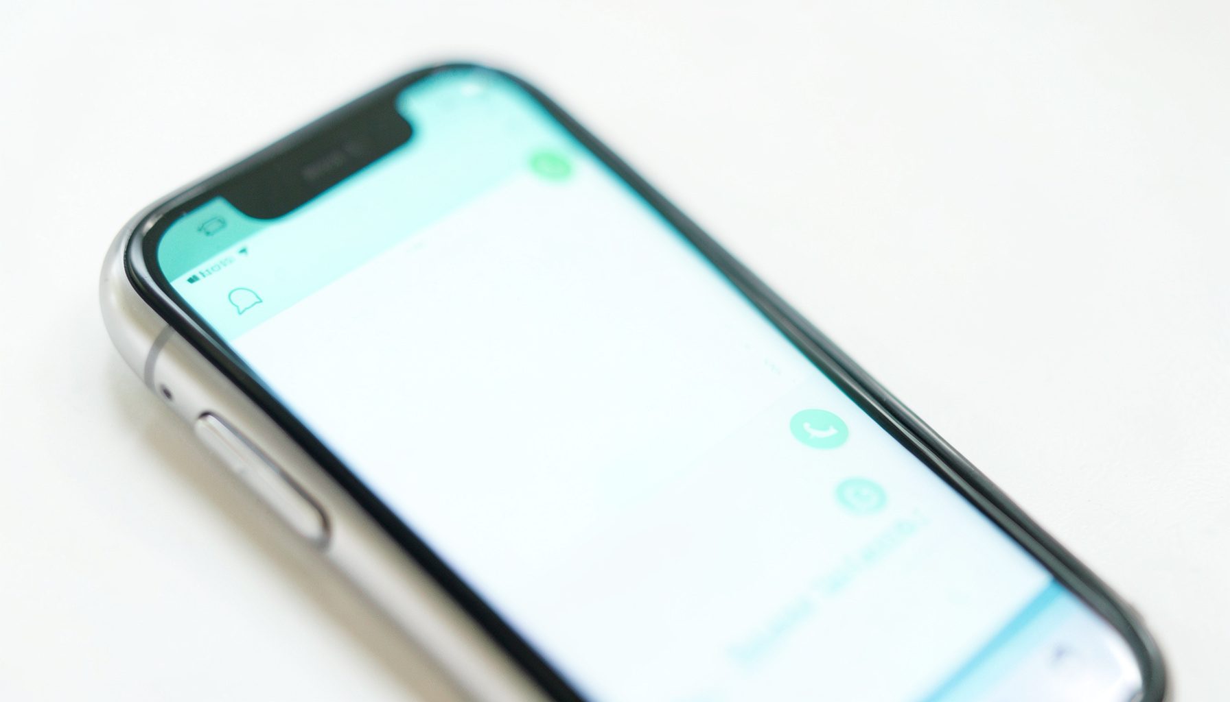 A close-up of a smartphone screen showing the WhatsApp interface with green chat bubbles, bright and clean composition