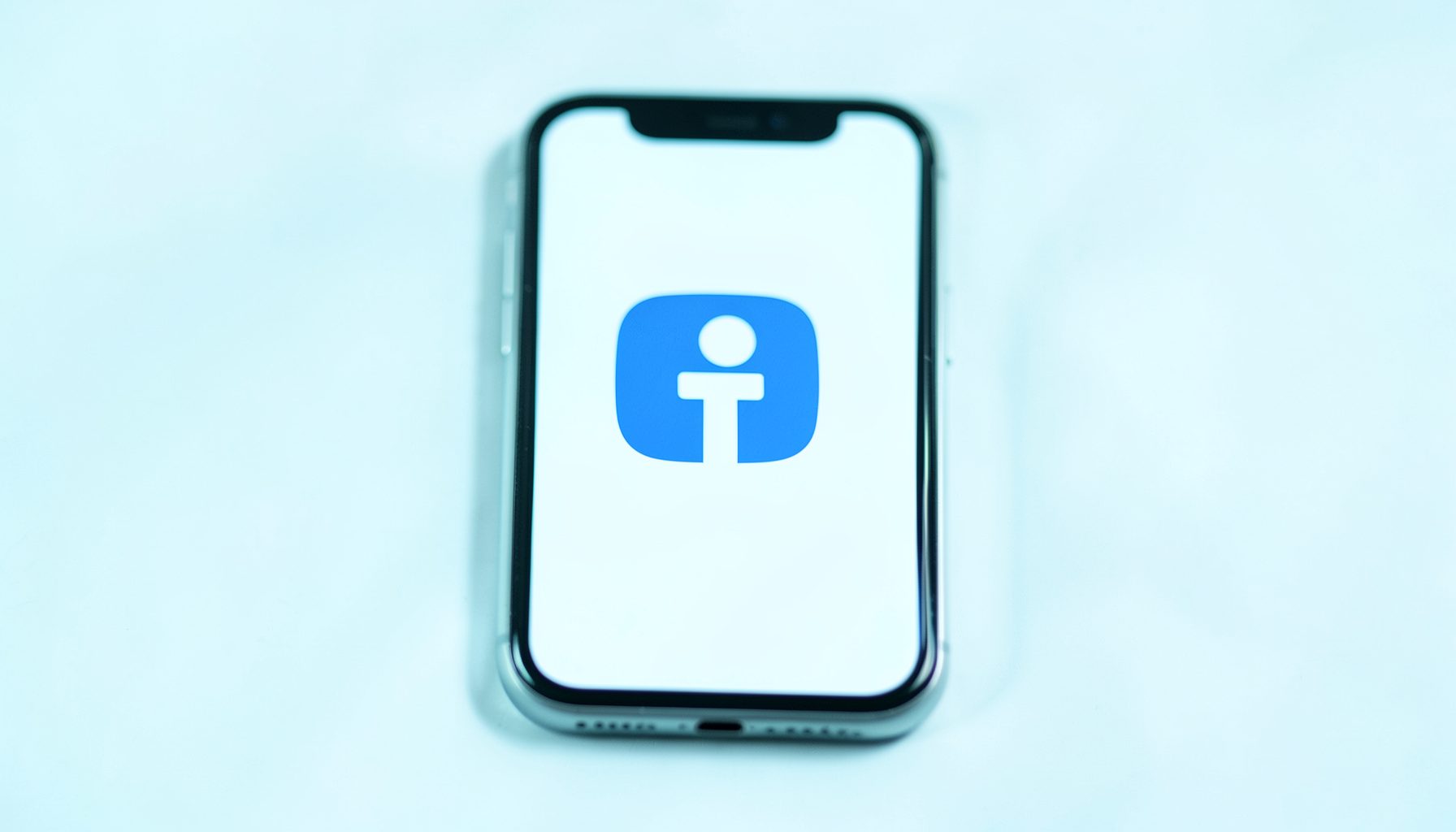 A smartphone screen showing the Facebook app icon alongside a warning symbol, moody blue-gray lighting
