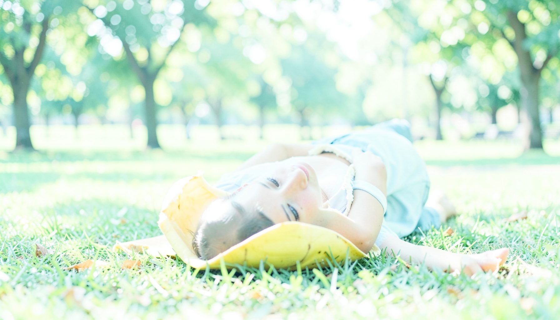 A person slipping on a banana peel in a sunny park, freeze-frame comedic moment, bright daylight, lighthearted tone